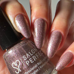 Close-up of a model's hand wearing Salon Perfect Flash Nail Lacquer .5oz Gliterally Obsessed holding the nail polish bottle.