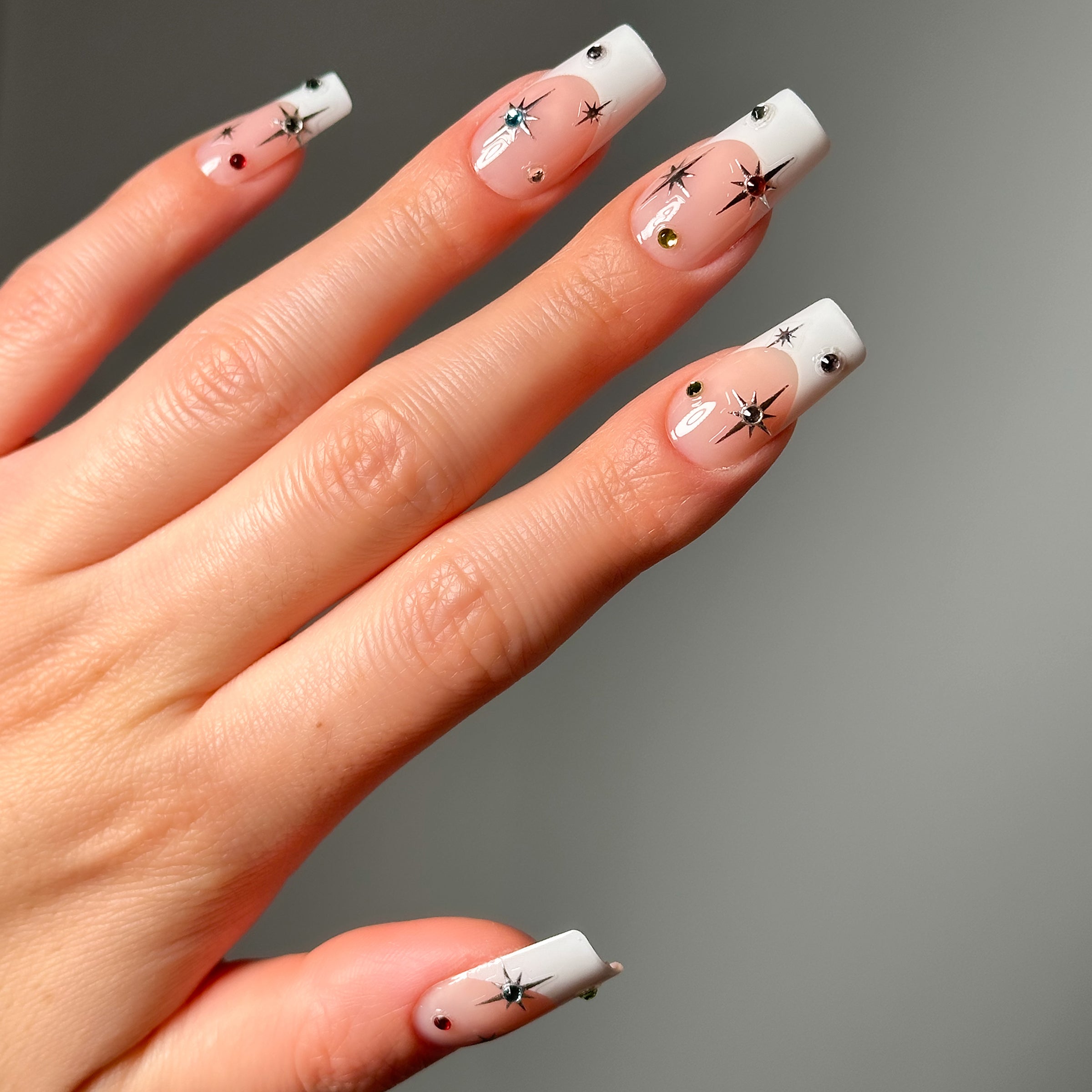 Close-up shot of a model's hand wearing Salon Perfect Nail Art Stickers Starbursts.
