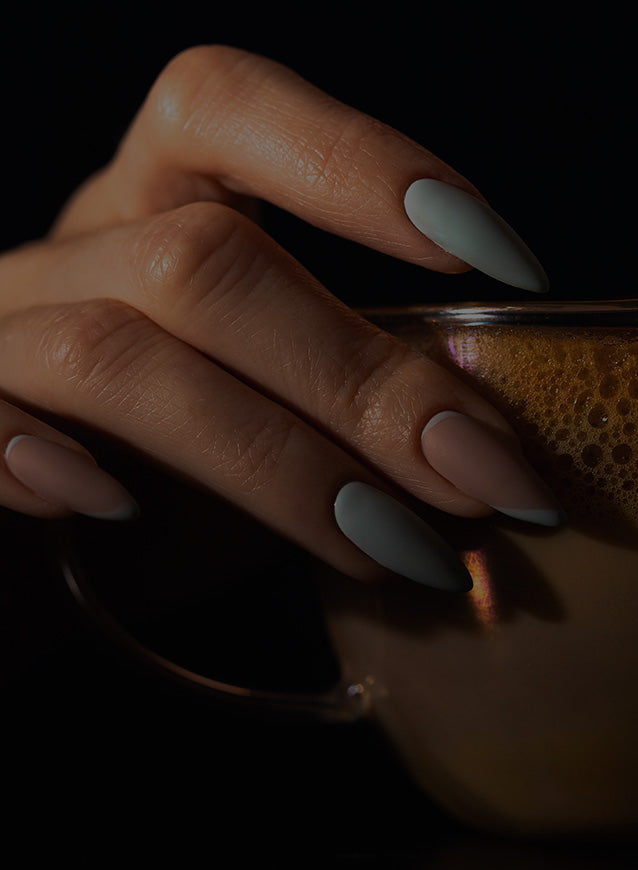 Close-up of a hand with press on nails  holding a an iced coffee. 