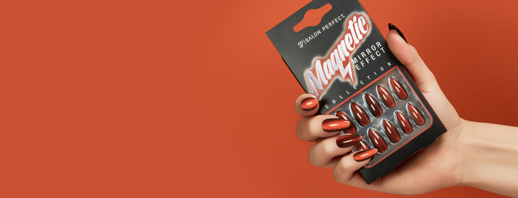 Hand holding a package of magnetic mirror effect press on nails against an orange background