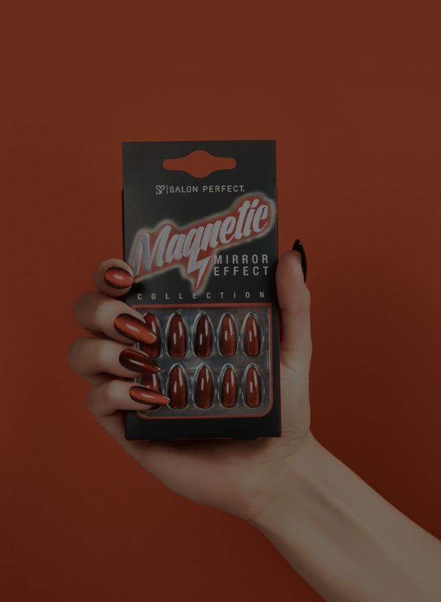 Hand holding a package of magnetic mirror effect press on nails against an orange background